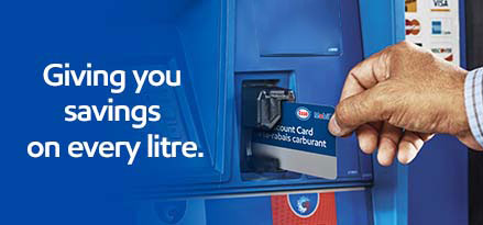 Person inserting Fuel Discount Card into gas pump