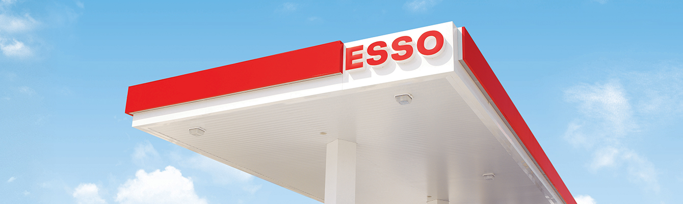Esso gas station canopy with Esso branding against a blue sky