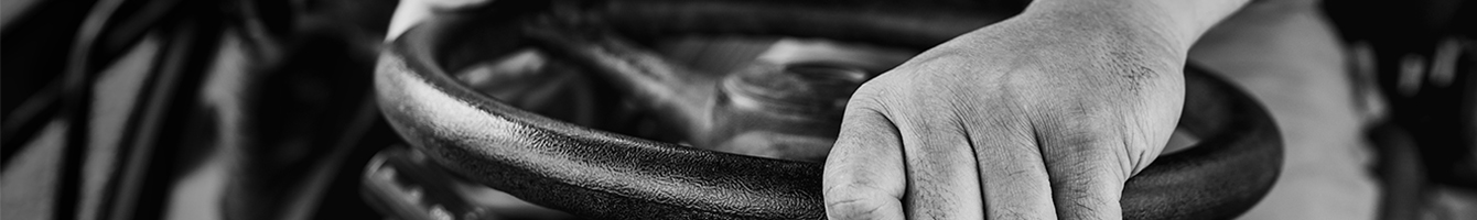 Photo en noir et blanc de mains sur un volant